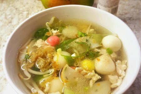 A bowl of savoury Tang Yuan with beansprouts, chicken, vegetables and seasoning.