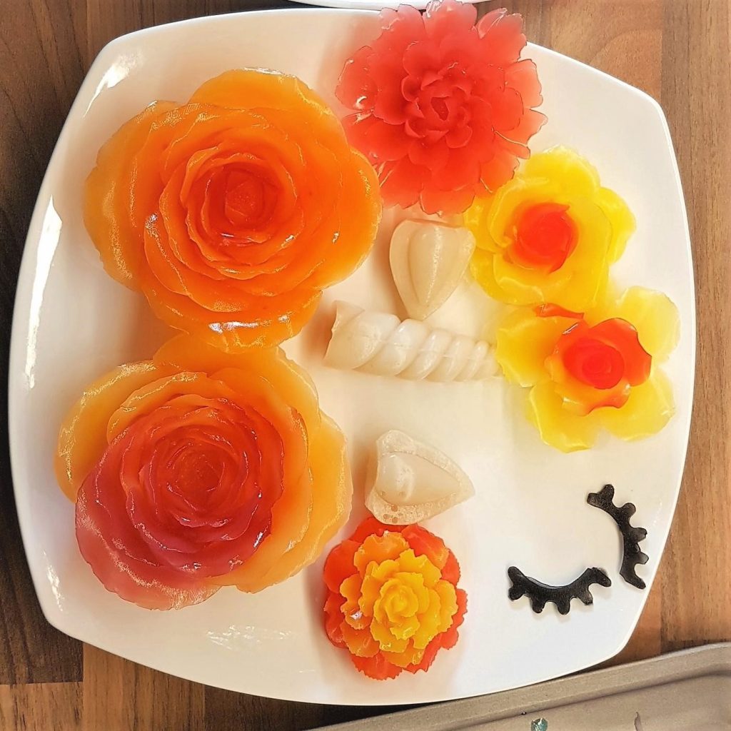 Flowers in various orange hue and unicorn horn, ears and eyes.