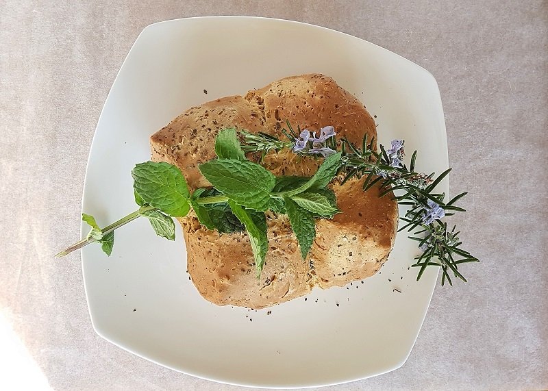 Finished soda bread decorated with mint and rosemary.