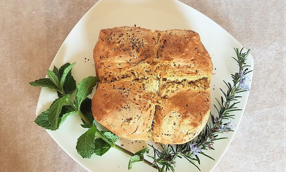 Finished soda bread decorated with mint and rosemary.