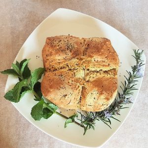 Finished soda bread decorated with mint and rosemary.