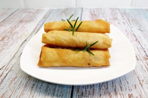 A stack of fried Spring rolls with fresh prawns.