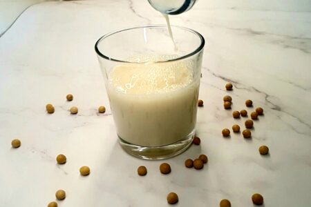 Soy milk being poured into a glass.