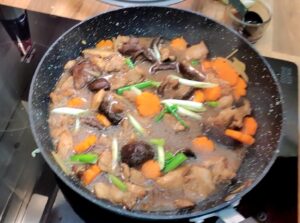 Chicken and oyster sauce cooking in a wok.