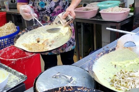 Making of banh seo in a wok.