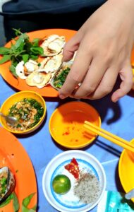 Grillled big clamps served with fish sauce, peanuts and spring onions dip.